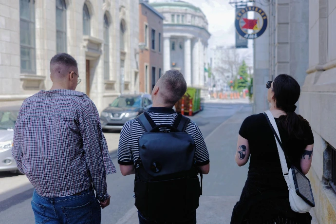 Deux hommes et une femme de dos en quête de découverte à Place-Royale